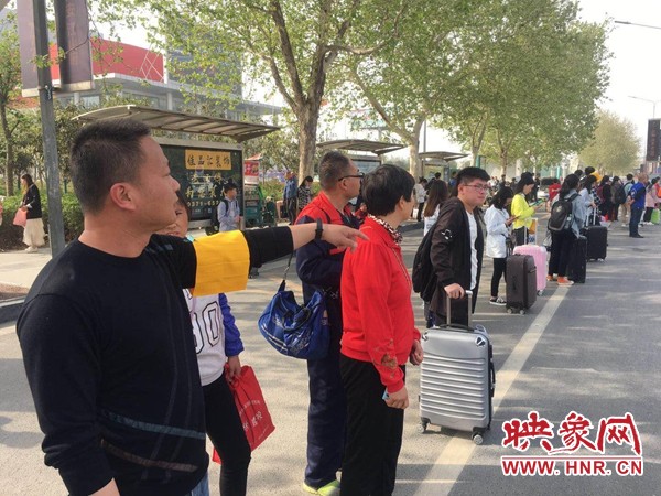 郑州迎来清明客流高峰 公交志愿者帮助市民乘车返程